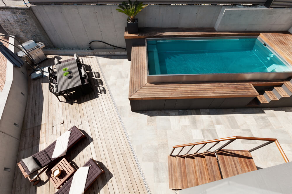 Mini piscine en bois sur terrasse vue aérienne avec table et transat